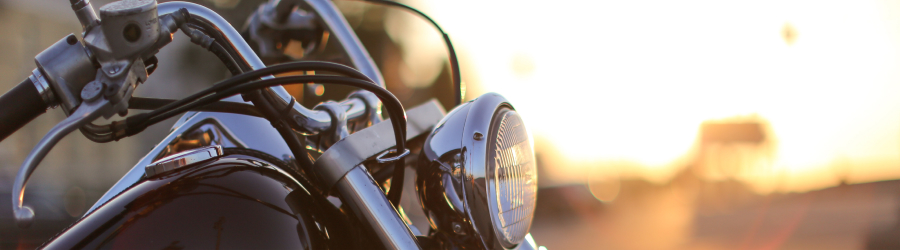 Parked motorcycle with sun setting in the background